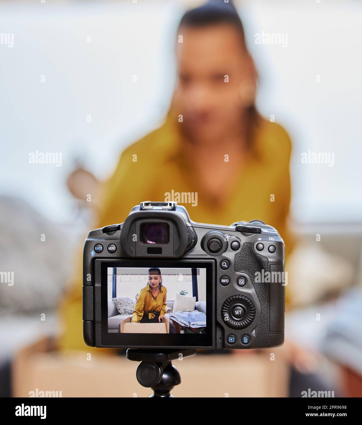 Vediamo cosa è nella scatola. Una giovane donna che registra un video per il suo vlog a casa. Foto Stock