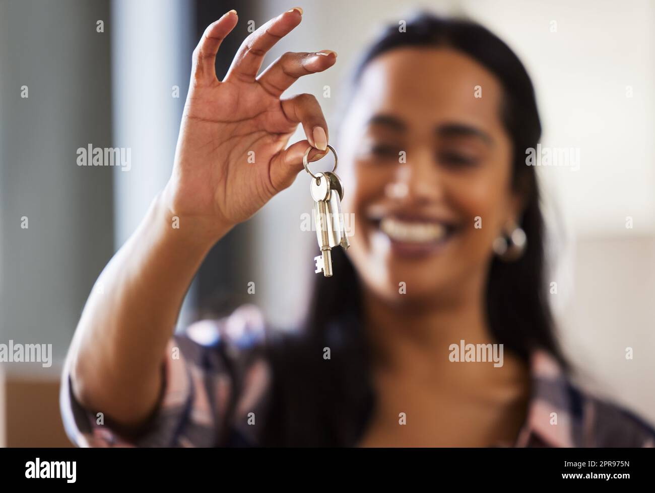 Per qualche casa in movimento è solo un'altra abitudine: Una giovane donna che mostra le chiavi per la sua nuova casa. Foto Stock