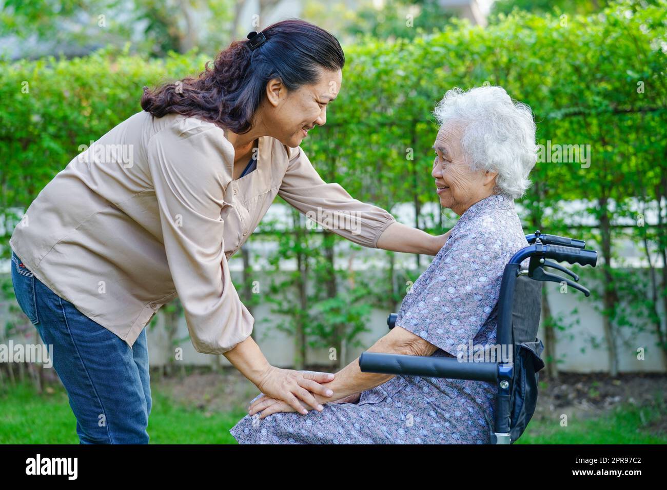 L'assistente aiuta il paziente asiatico anziano di disabilità della donna in ospedale di cura, concetto medico. Foto Stock