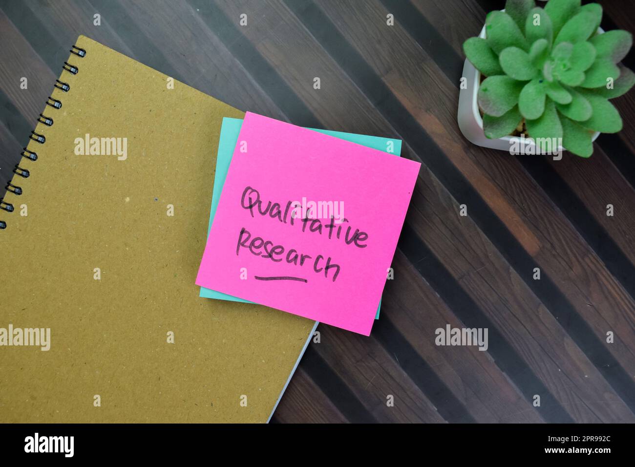 Concetto di Ricerca qualitativa scrivere su note appiccicose isolate su tavola di legno. Foto Stock