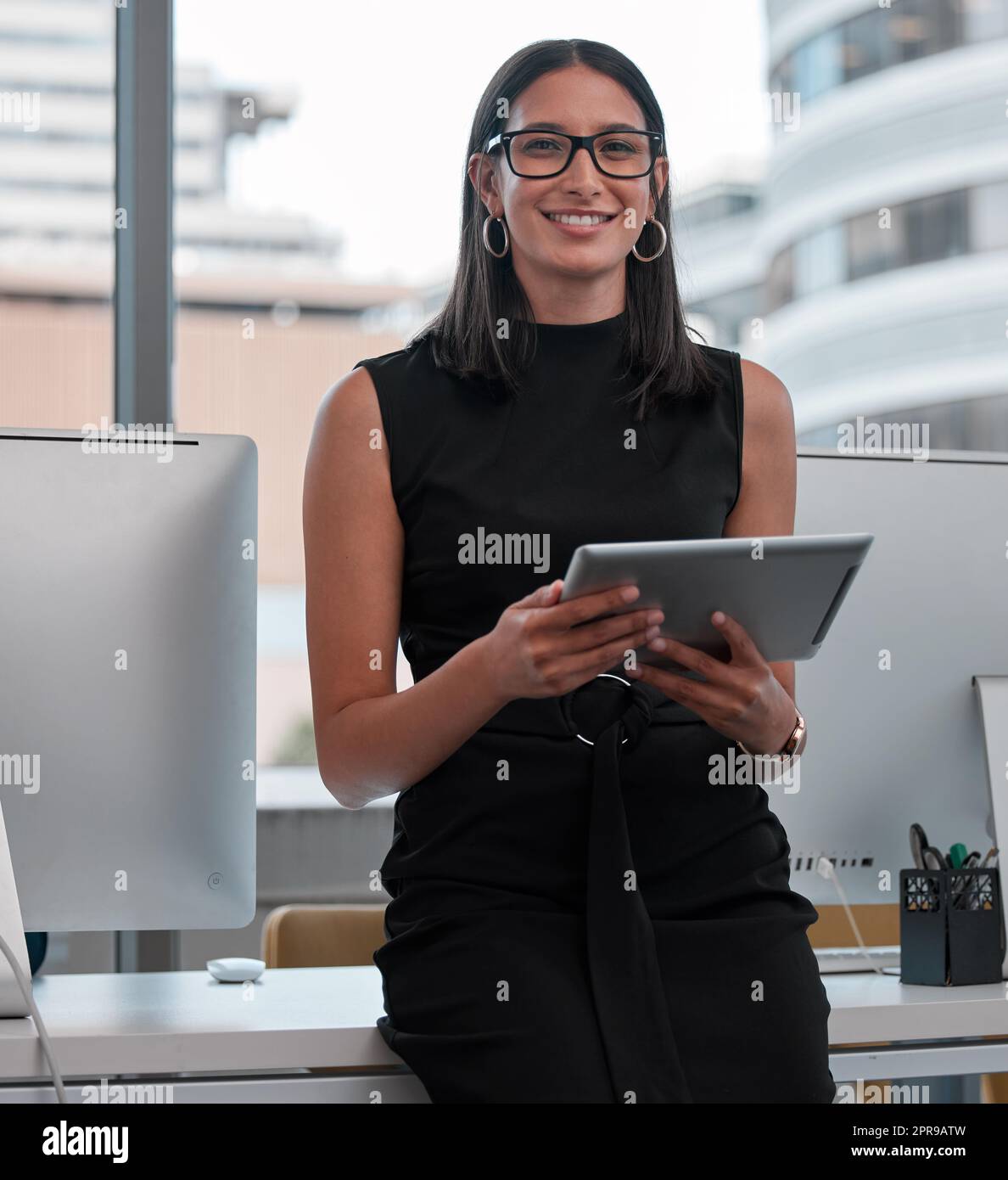 La gente diventa spesso ciò che crede di essere: Una giovane donna che usa un tablet in ufficio. Foto Stock