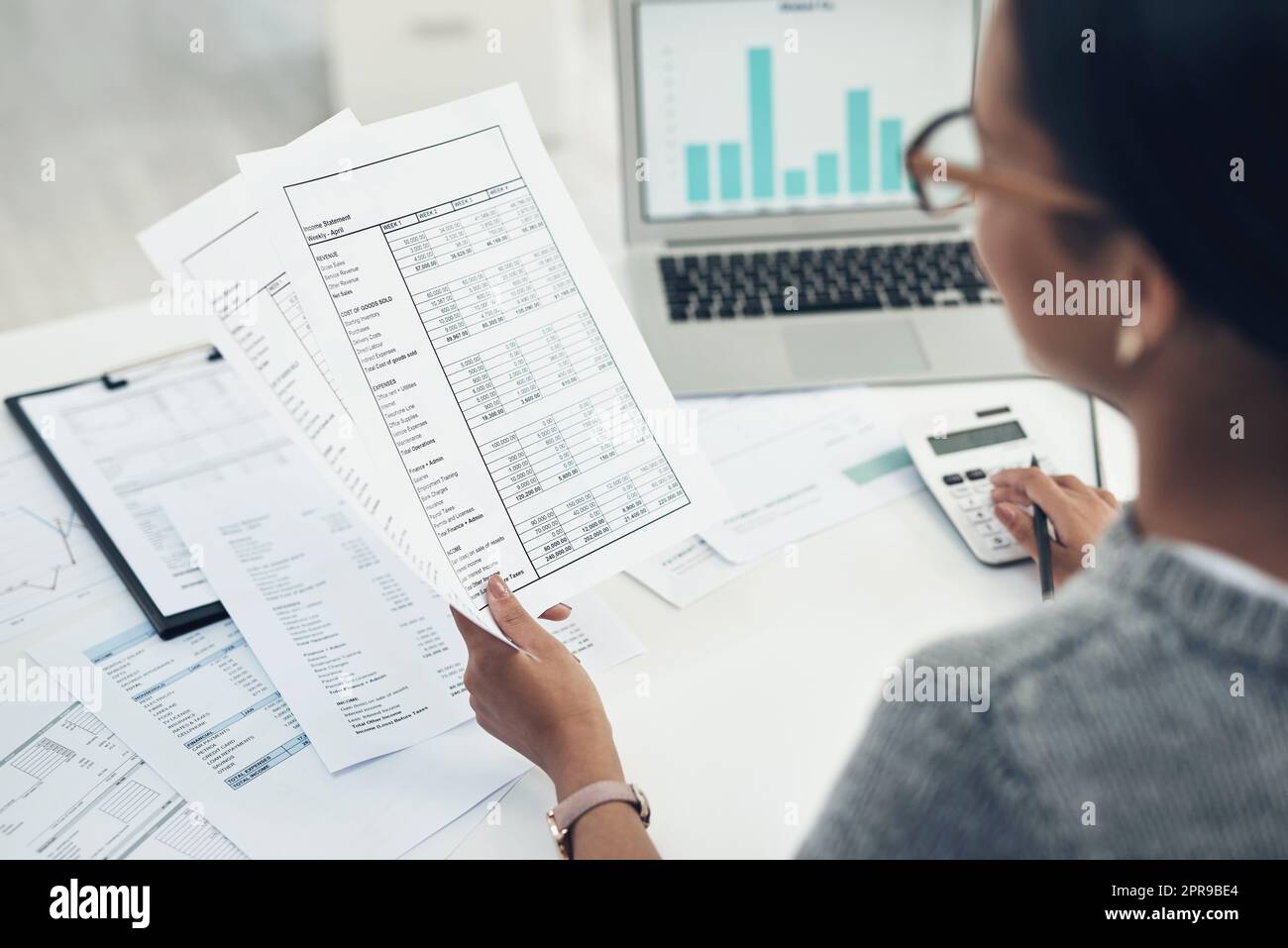 Revisione dei documenti necessari per l'archiviazione. Primo piano di un'irriconoscibile donna d'affari che calcola le finanze in un ufficio. Foto Stock