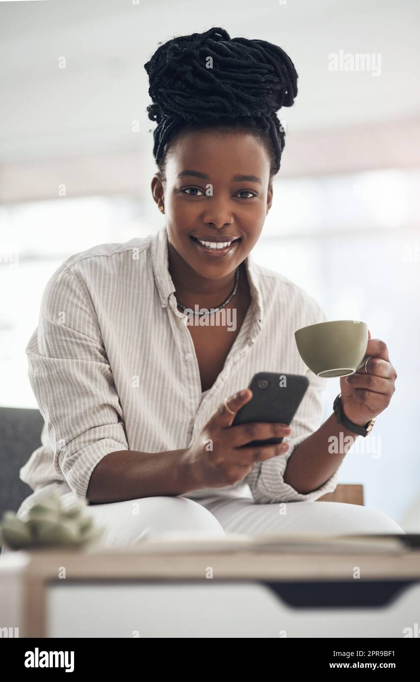 Fare una pausa caffè è fondamentale per la salute. Una donna d'affari che usa il suo smartphone per inviare messaggi di testo mentre beve il caffè. Foto Stock