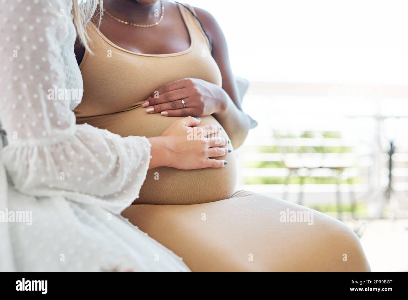 La sensazione è indescrivibile: Una donna che tocca i suoi amici incinta ventre. Foto Stock