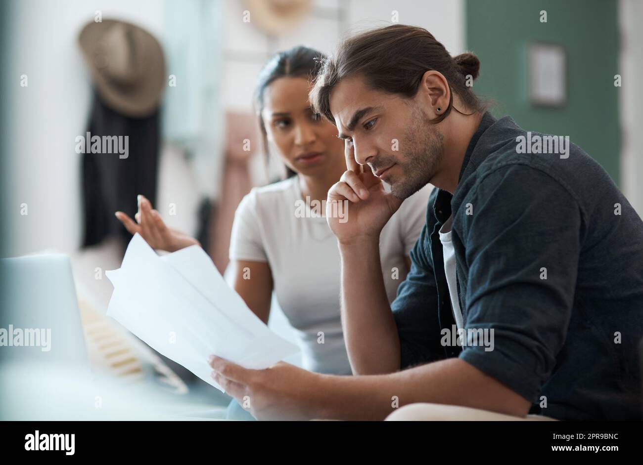 Come risolveremo questo problema: Una coppia giovane ha un argomento mentre fa lavoro di ufficio a casa. Foto Stock