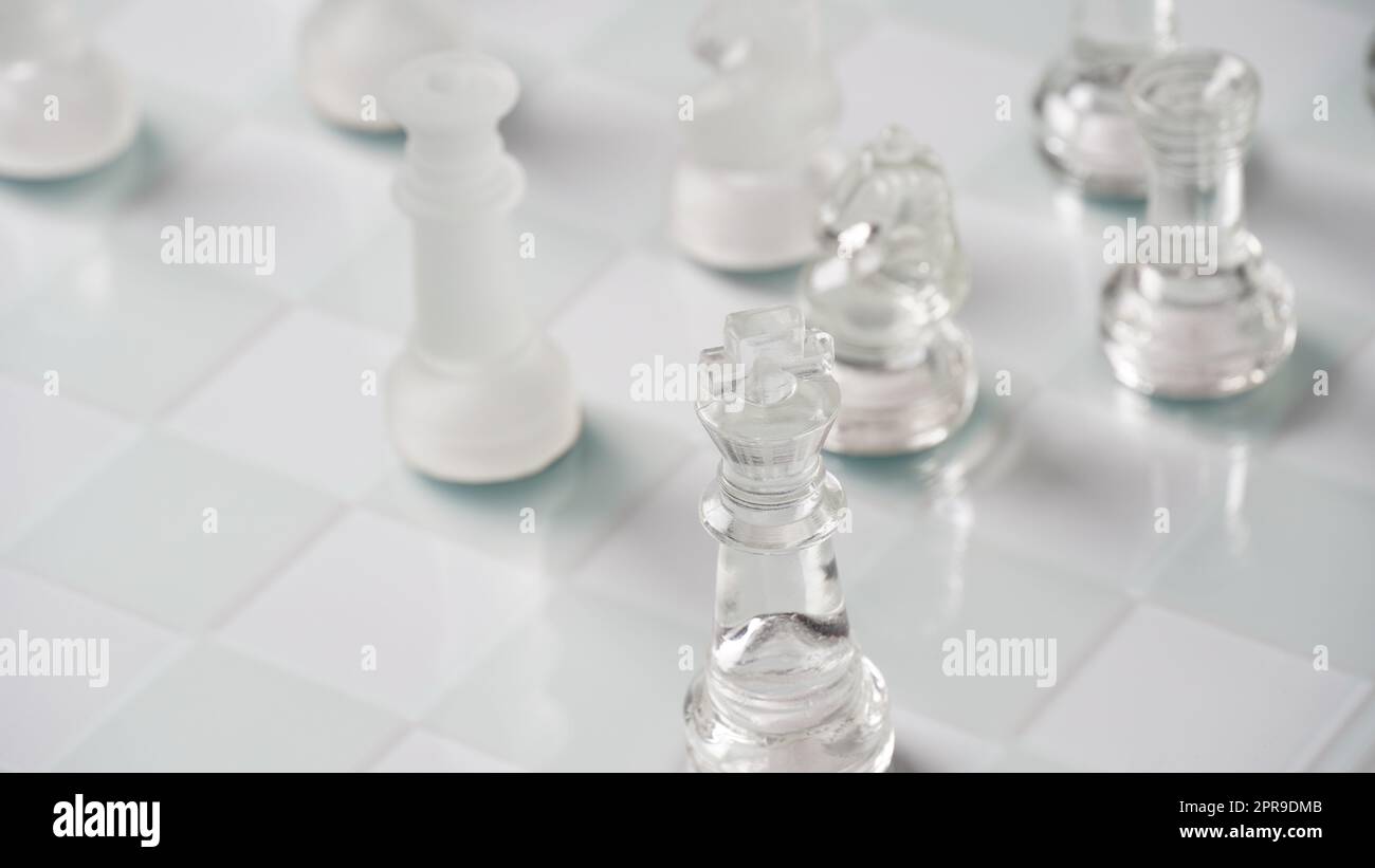 Figure di scacchi trasparenti, in posizione di partenza, su scacchiera riflettente, tono rosso. Gioco da tavolo Scacchi strategico Foto Stock