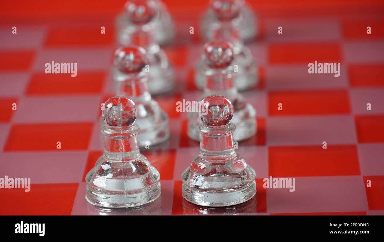 Pezzi di scacchi trasparenti, pedine. Scacchi trasparenti su scacchiera, tono rosso. Foto Stock