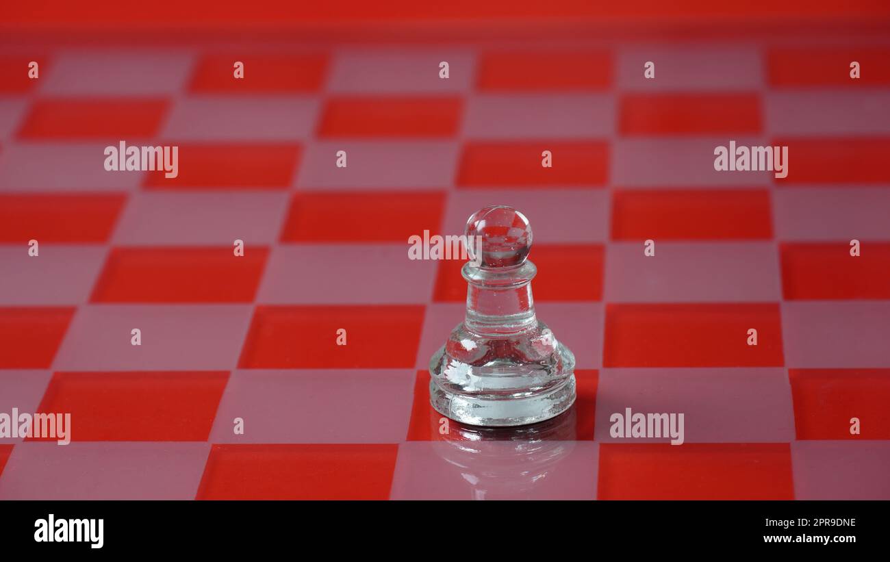 Pezzo di scacchi trasparenti, pedina. Scacchi trasparenti su scacchiera, tono rosso. Foto Stock