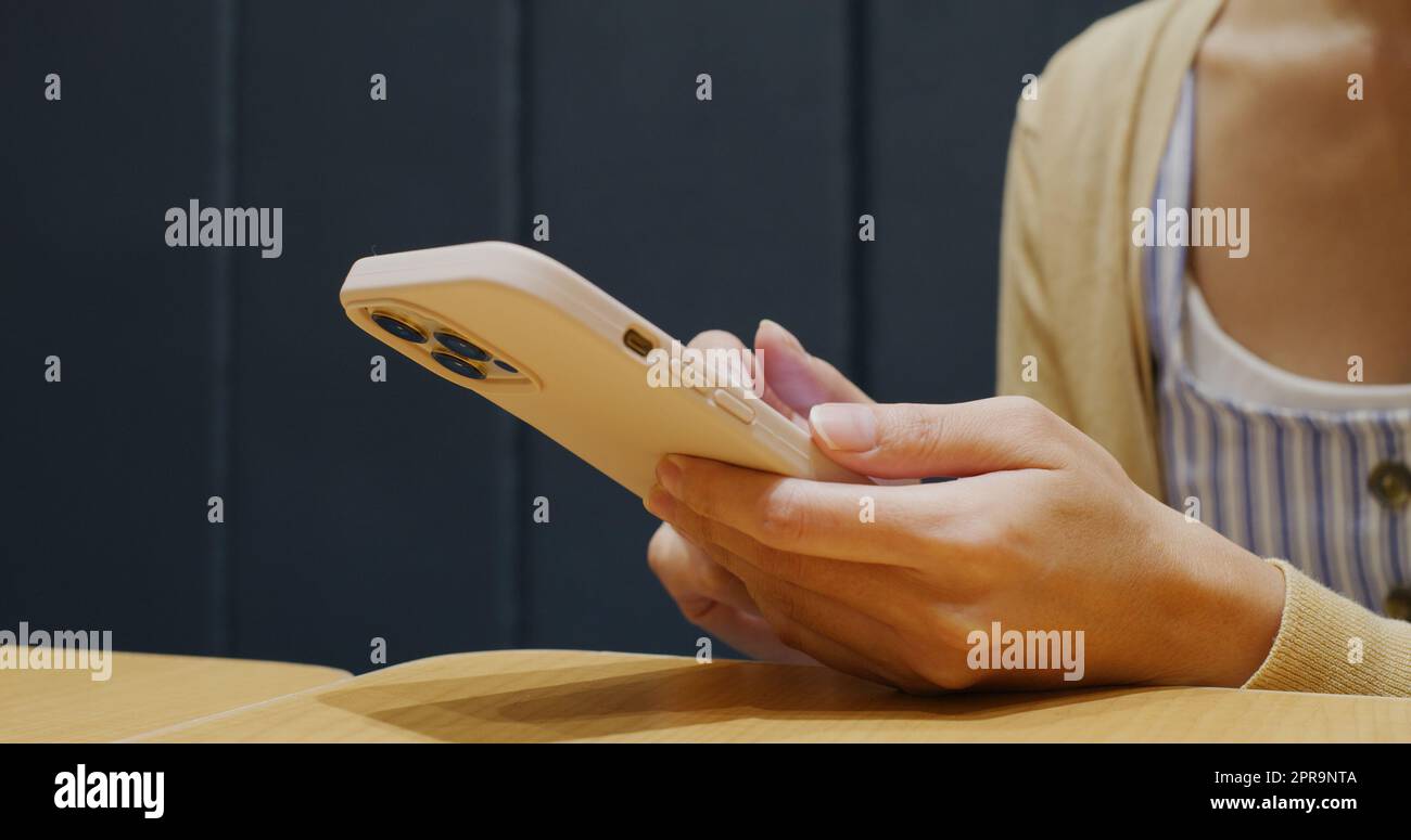 Donna uso del telefono cellulare al ristorante Foto Stock