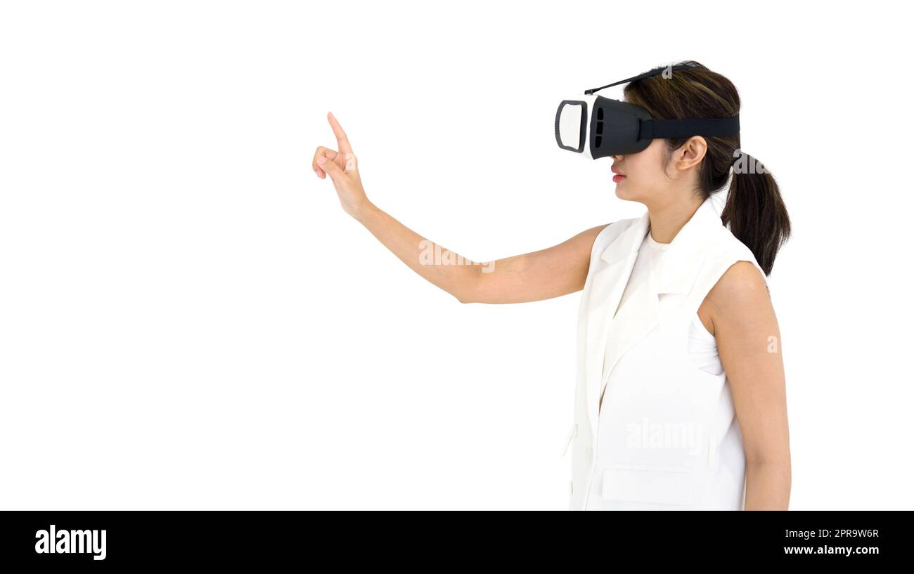 Donna asiatica in abito bianco utilizzando occhiali di realtà virtuale, giocare un gioco interattivo. Vista laterale. Il concetto di tecnologia del futuro. Foto Stock