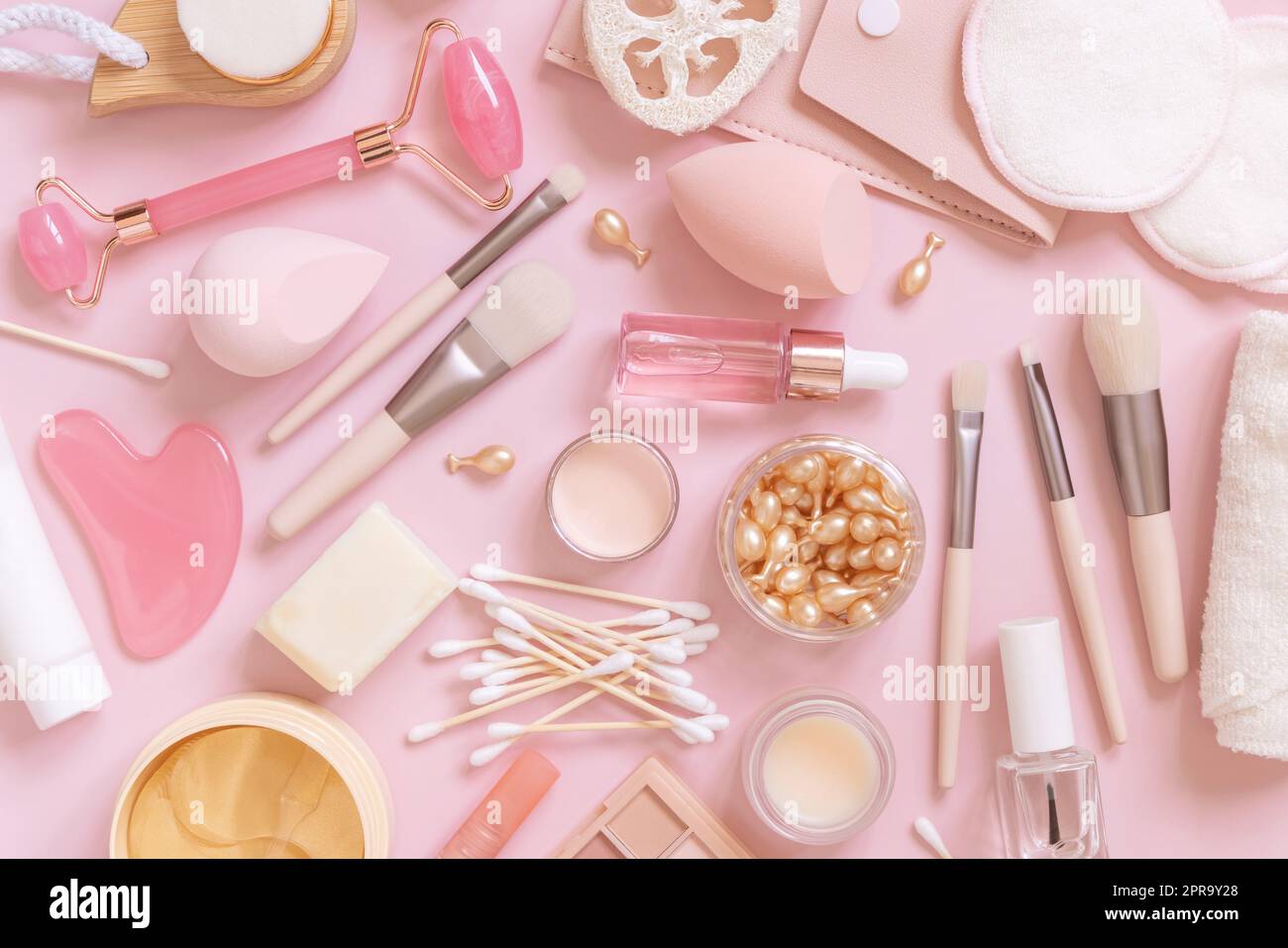 Prodotti naturali per la cura della pelle e cosmetici decorativi in rosa chiaro, vista dall'alto Foto Stock