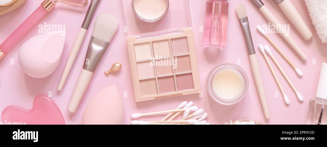 Prodotti naturali per la cura della pelle e cosmetici decorativi in rosa chiaro, vista dall'alto Foto Stock