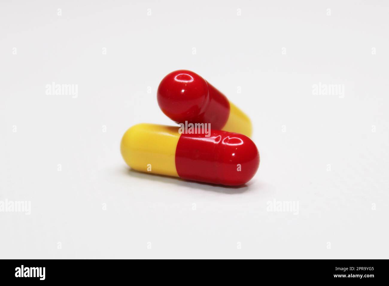 Due capsule medicinali in primo piano su uno sfondo chiaro. Concetto di assistenza sanitaria Foto Stock
