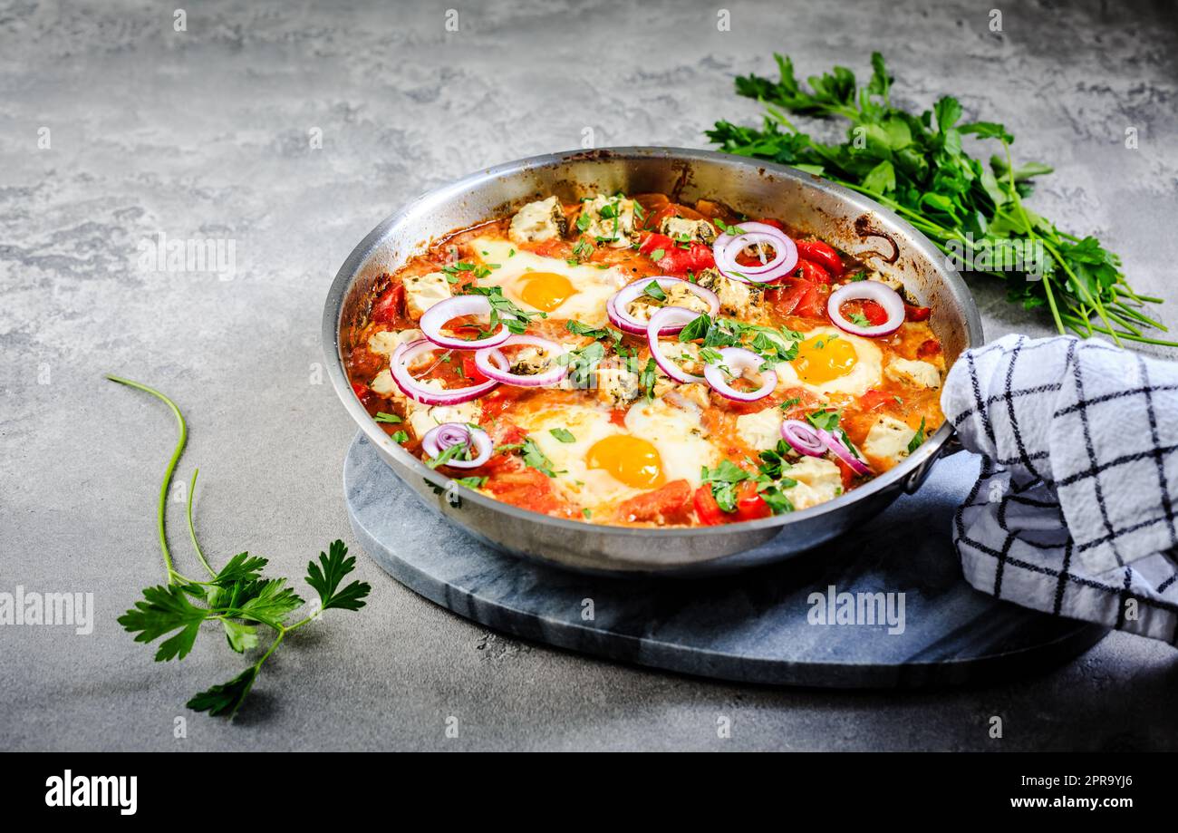 Shakshouka - uova in camicia in salsa di pomodori, peperoni, cipolla e formaggio feta. Pasto keto e carb basso Foto Stock
