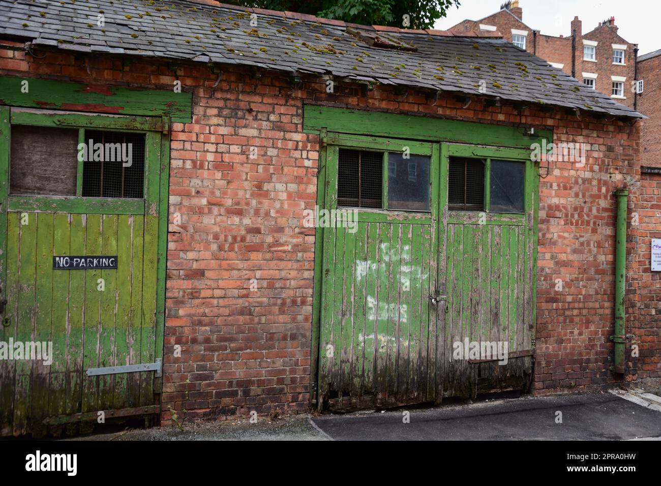 Porte rustiche in legno in un garage in mattoni rossi Foto Stock