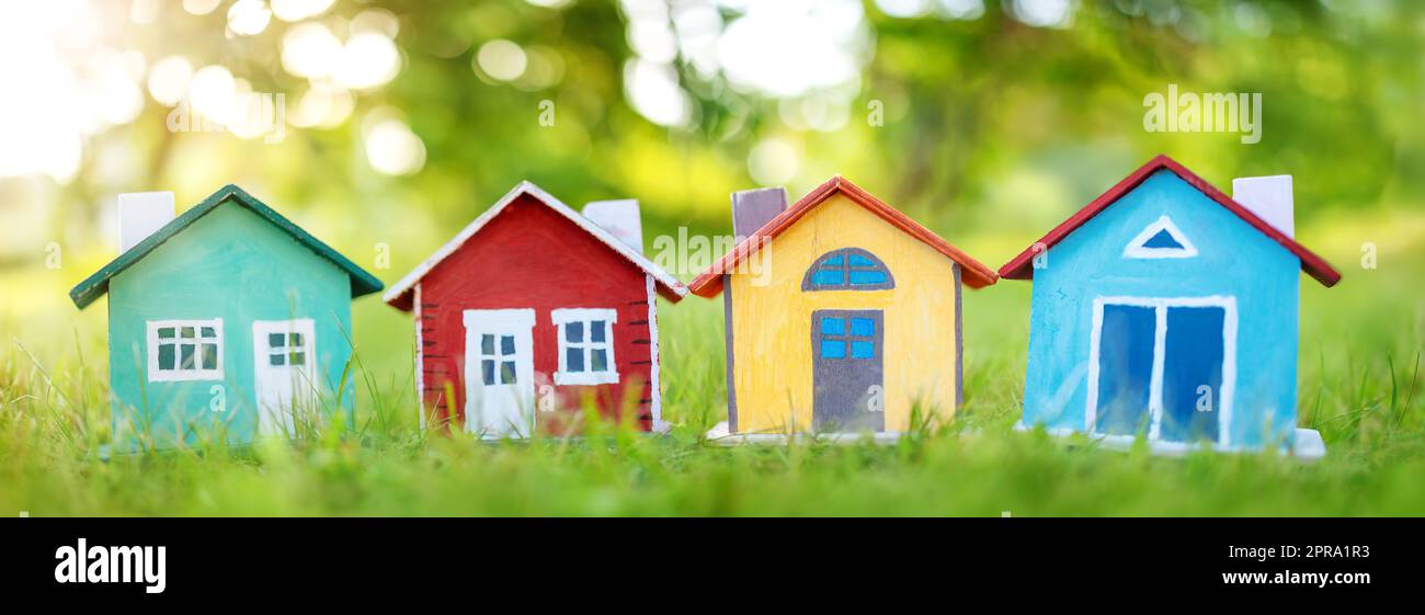 Diversi modelli di case colorate in piedi sull'erba verde. Foto Stock
