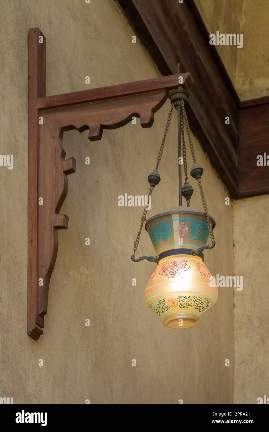 Lanterna da strada in vetro arabo d'epoca appesa a un palo di legno Foto Stock