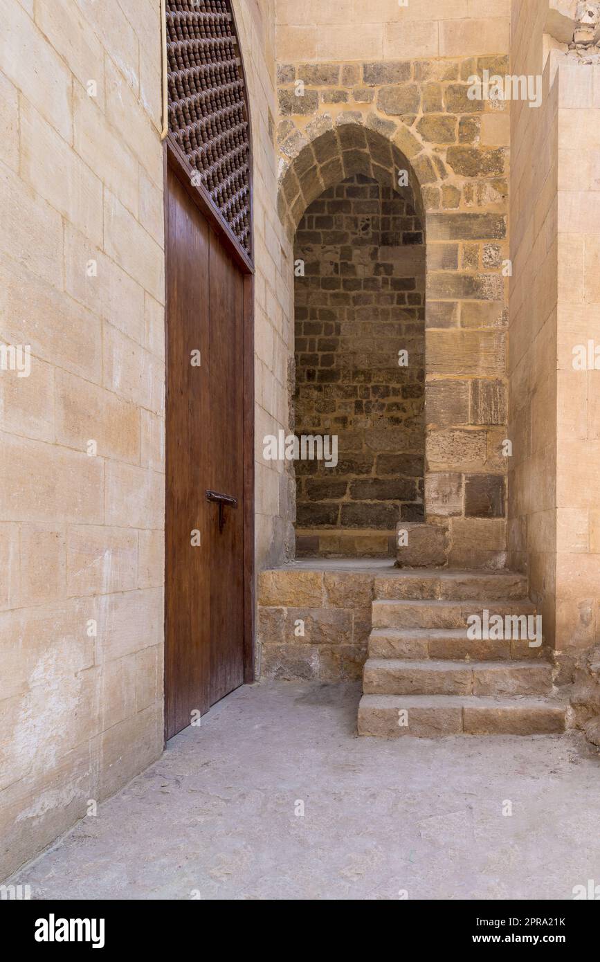 Scalinata in pietra che porta all'ingresso a volta presso il muro di pietra in mattoni Foto Stock