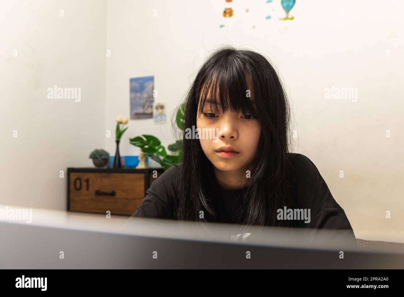 Asian teen ragazza utilizzare computer laptop tecnologia Internet ricerca online informazioni social network e istruzione compiti a casa sul tavolo. Foto Stock