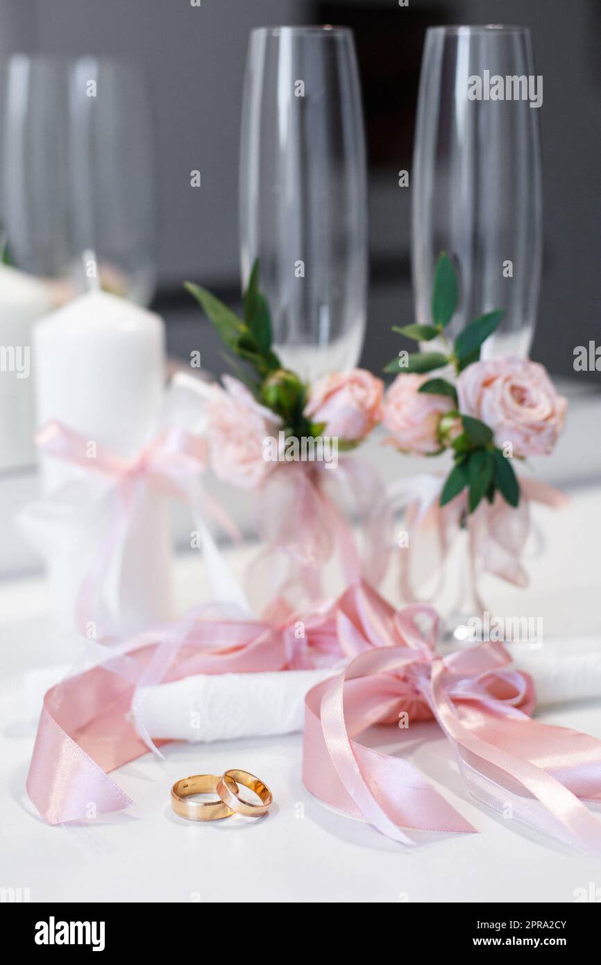 Anelli e dettagli nuziali in stile rosa, che sono sul tavolo. Foto Stock