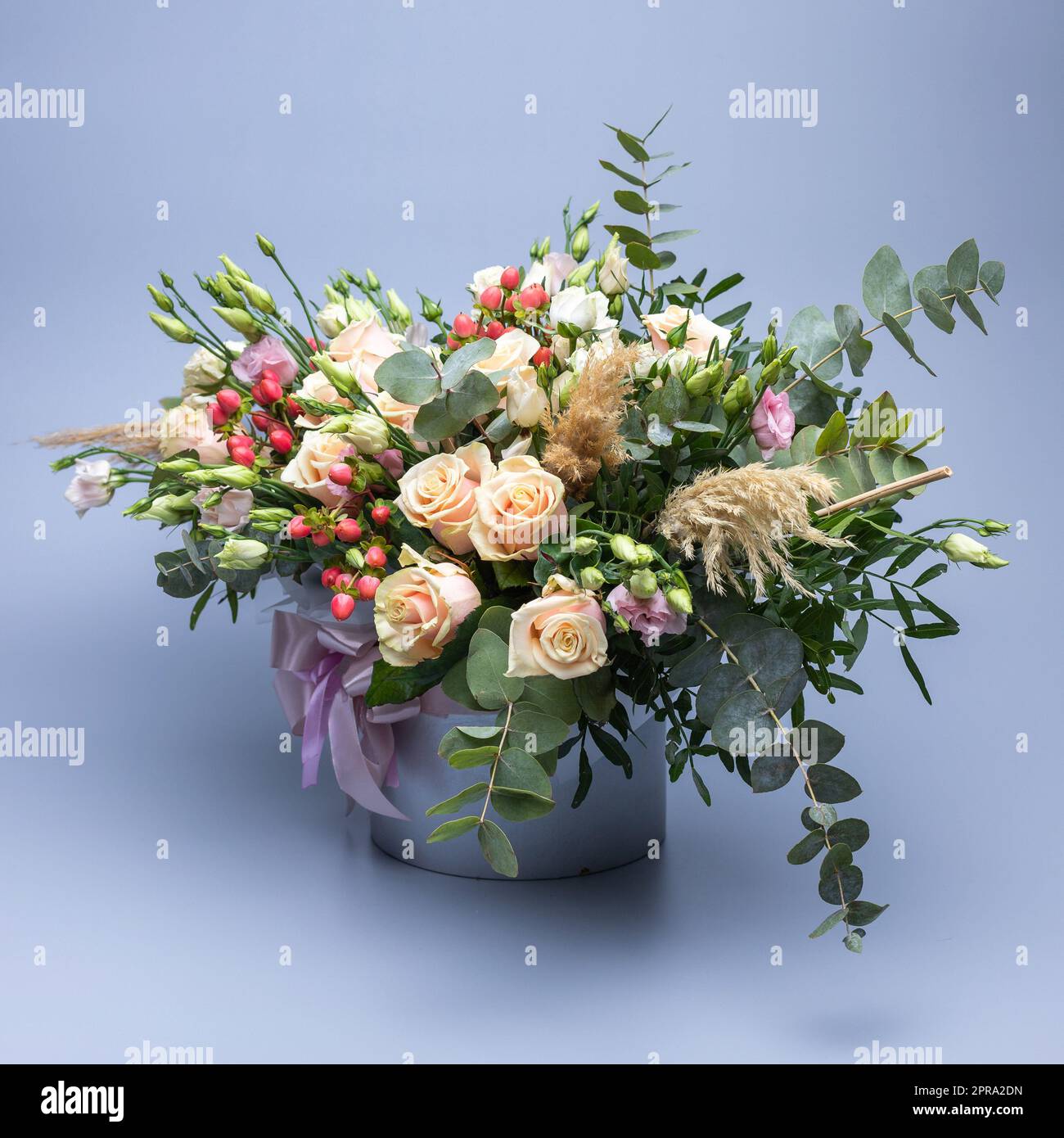 Bouquet di colore pastello composto da rose, altri fiori diversi e ciuffi di verde. Foto Stock