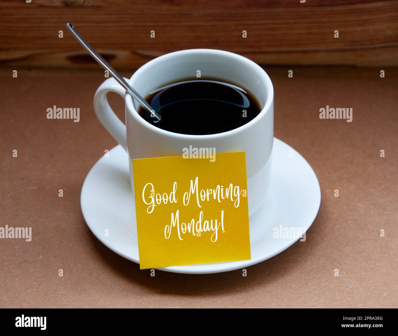 Messaggio di saluto mattutino su un blocco note giallo sulla tazza di caffè - Buongiorno lunedì Foto Stock