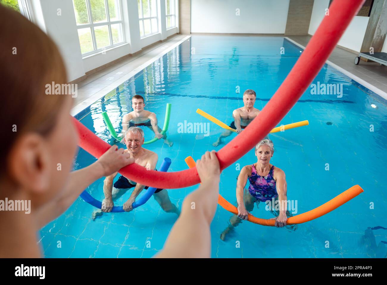 Persone in aqua fitness class durante una terapia fisica sessione Foto Stock