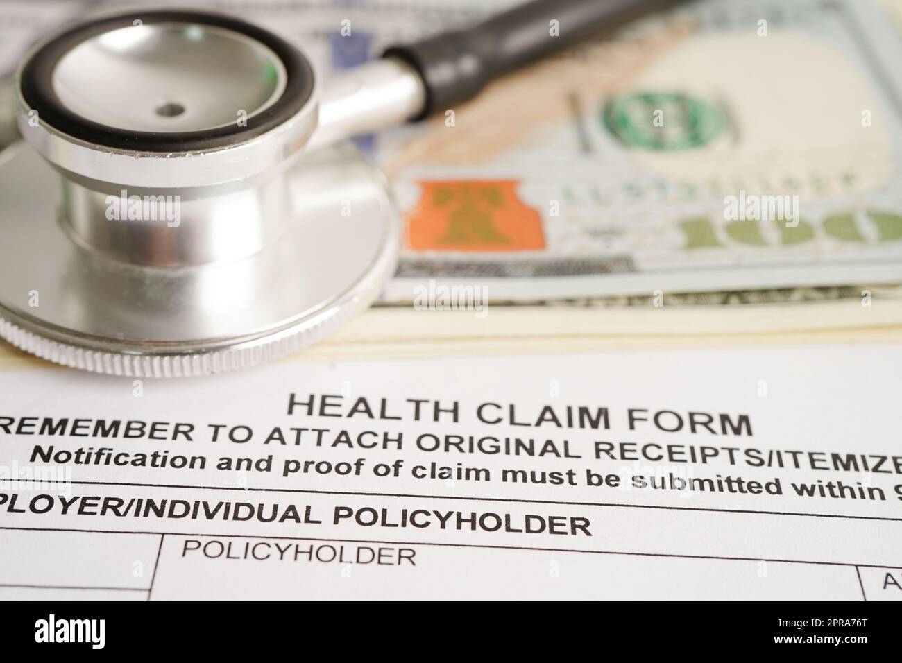 Forma di reclamo sanitario con stetoscopio e banconote in dollari USA, assicurazione incidente concetto medico. Foto Stock