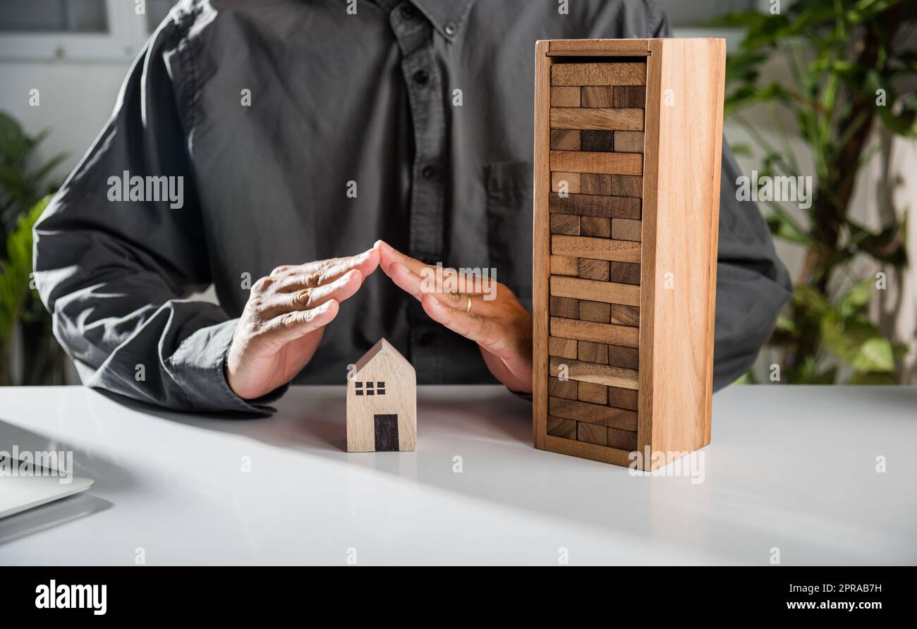 Man mano blocchi di legno blocco da molti fila caduta blocco di legno come domino a casa modello Foto Stock