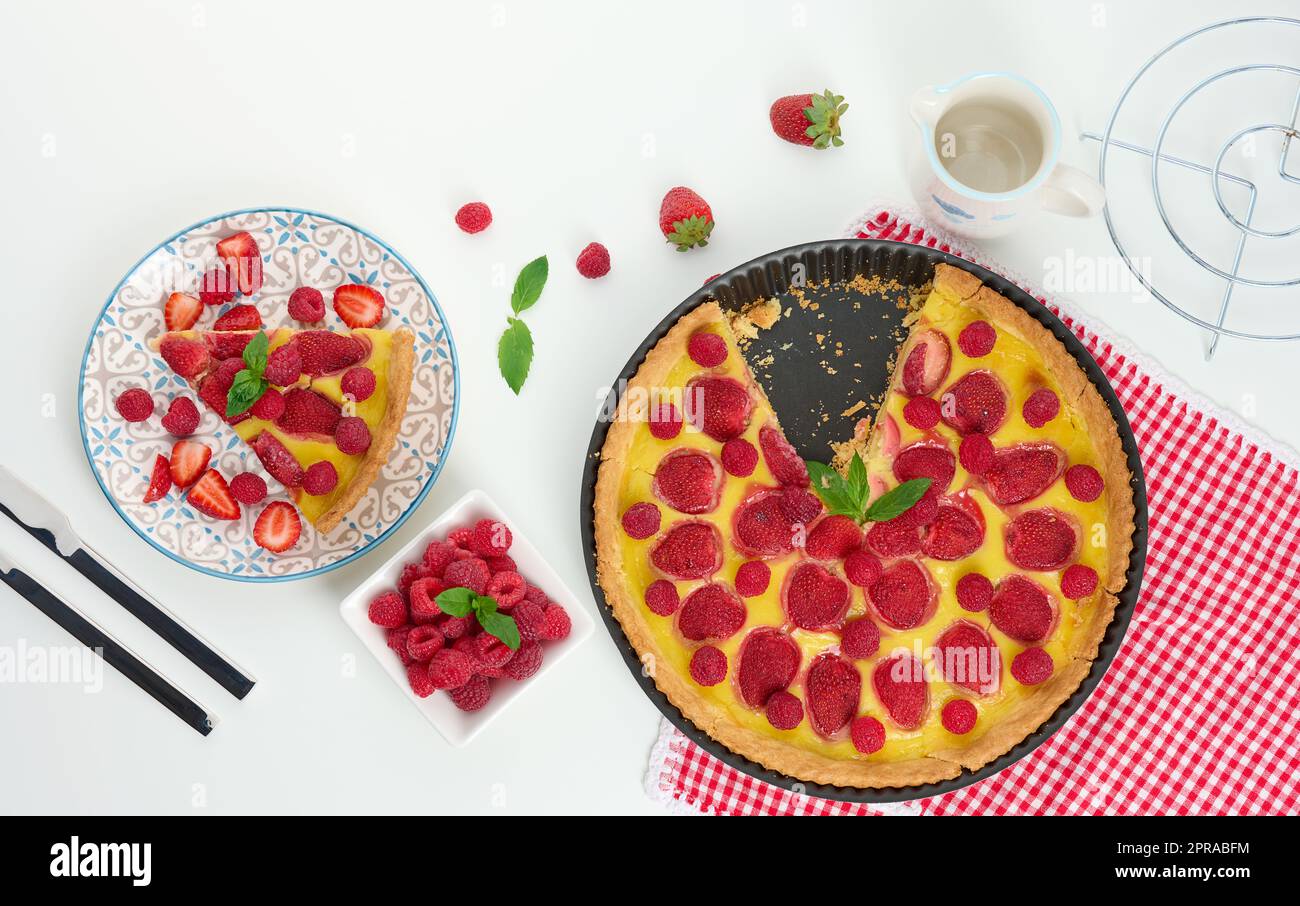 Quiche rotonde con fragole rosse e lamponi su una tavola bianca Foto Stock