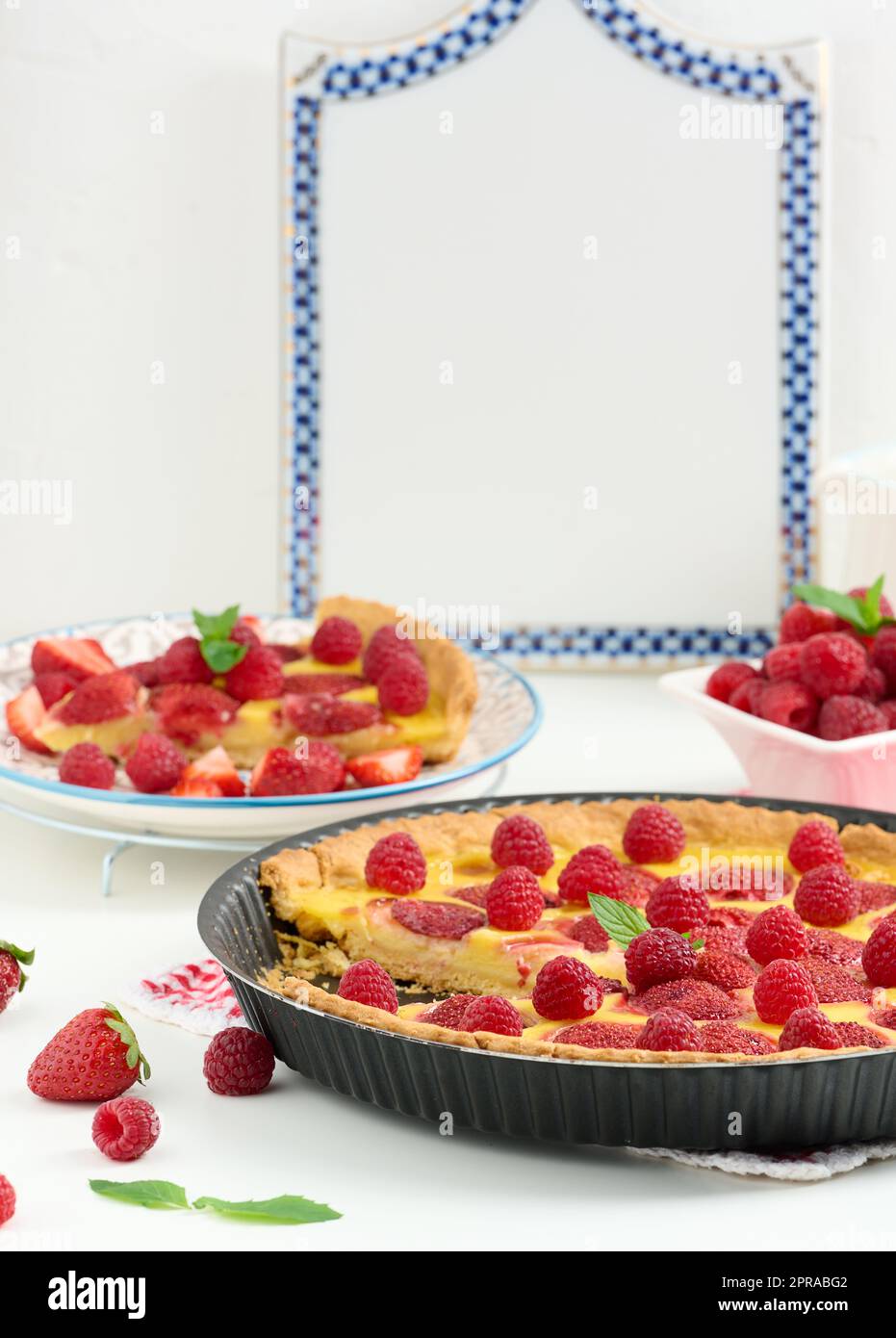 Quiche rotonde con fragole rosse e lamponi su un tavolo bianco, vista dall'alto Foto Stock