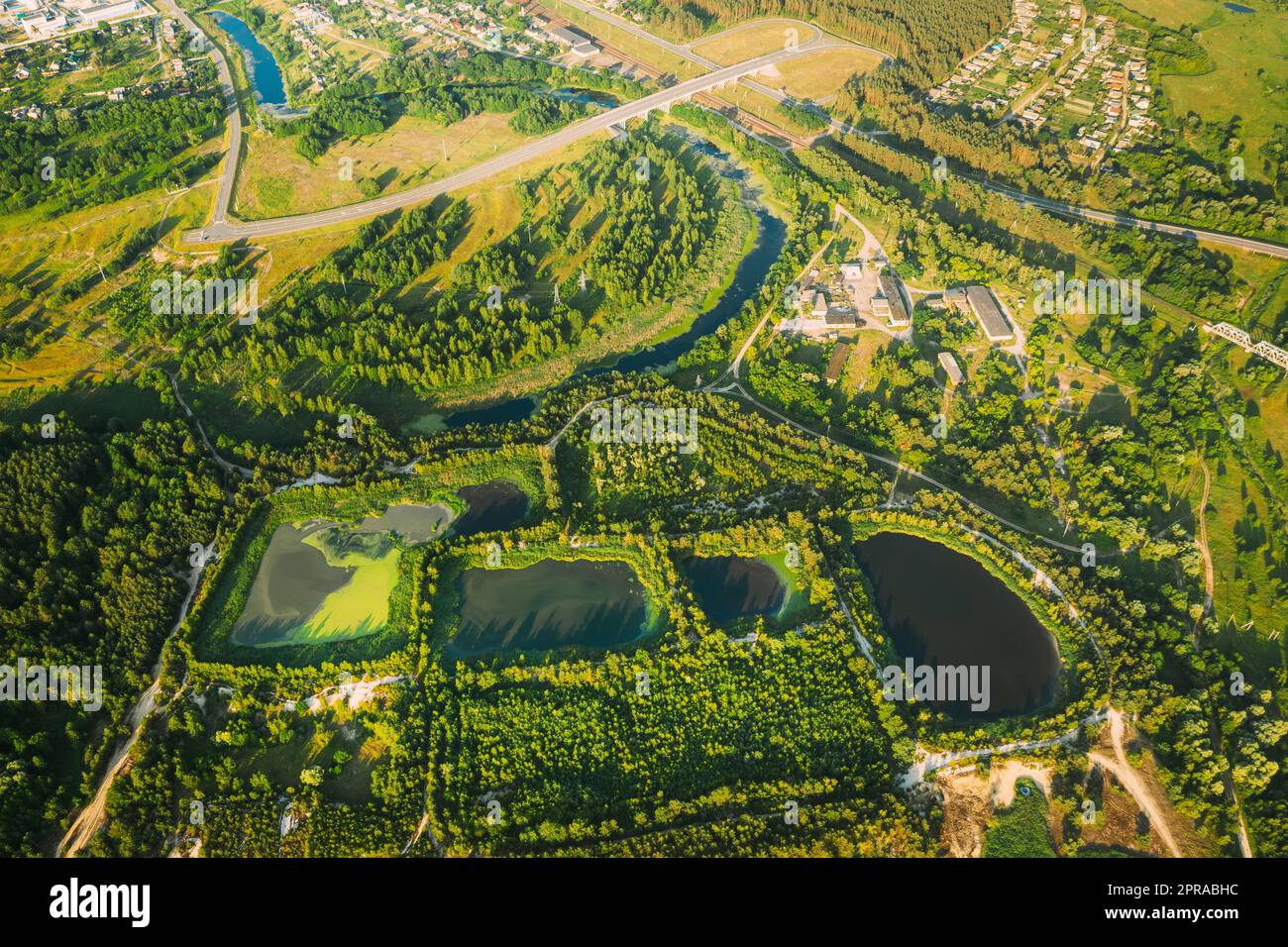 Bacini di ritenzione per la vista aerea, laghetto bagnato, bacino di ritenzione bagnato o stagno di gestione delle acque piovane, è uno stagno artificiale con vegetazione intorno al perimetro e include Una piscina d'acqua permanente nel suo design. Foto Stock