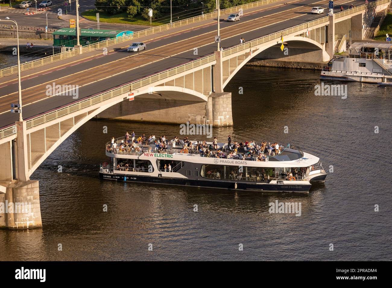 PRAGA, REPUBBLICA CECA - la barca turistica passa sotto Stefanikuv Most, il ponte di Stefanik, sul fiume Moldava. Foto Stock