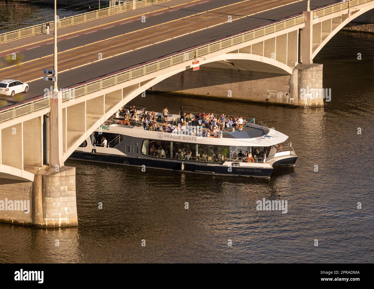 PRAGA, REPUBBLICA CECA - la barca turistica passa sotto Stefanikuv Most, il ponte di Stefanik, sul fiume Moldava. Foto Stock