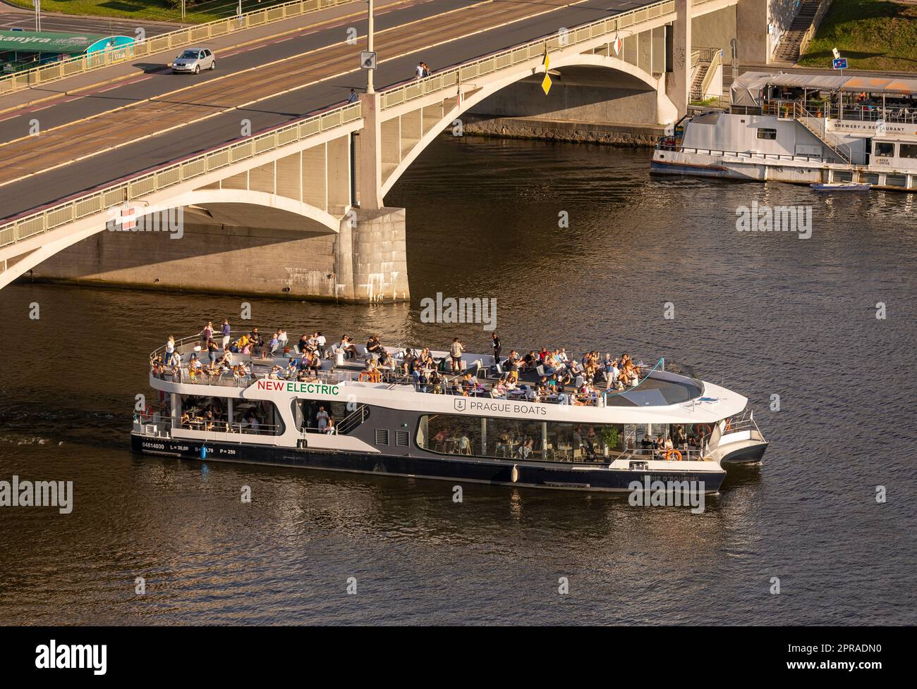 PRAGA, REPUBBLICA CECA - la barca turistica passa sotto Stefanikuv Most, il ponte di Stefanik, sul fiume Moldava. Foto Stock