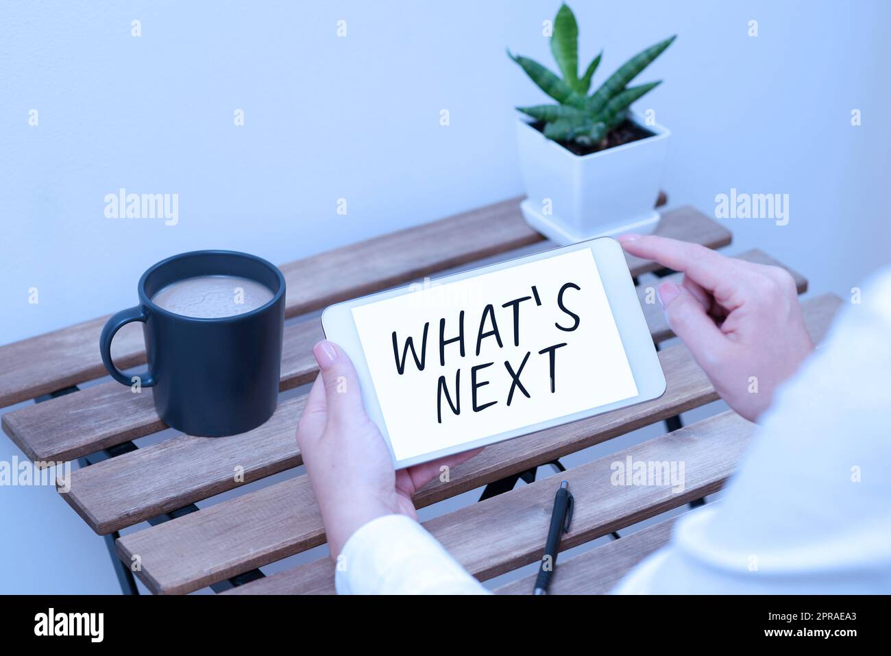 Segno che mostra cosa S è il prossimo. Parola scritta sul chiedere cosa viene subito dopo l'attuale una donna che detiene tablet con dati recenti sulla tabella con caffè, penna e impianto Foto Stock