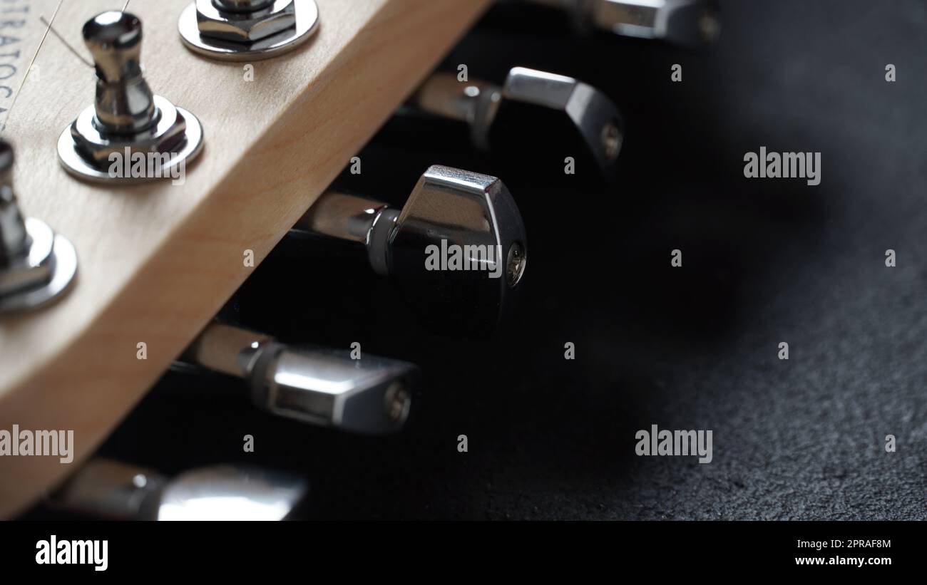 Primo piano dei tasti di sintonizzazione di una chitarra acustica Foto Stock