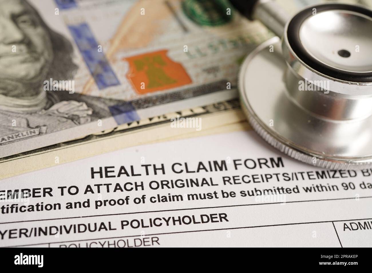 Forma di reclamo sanitario con stetoscopio e banconote in dollari USA, assicurazione incidente concetto medico. Foto Stock