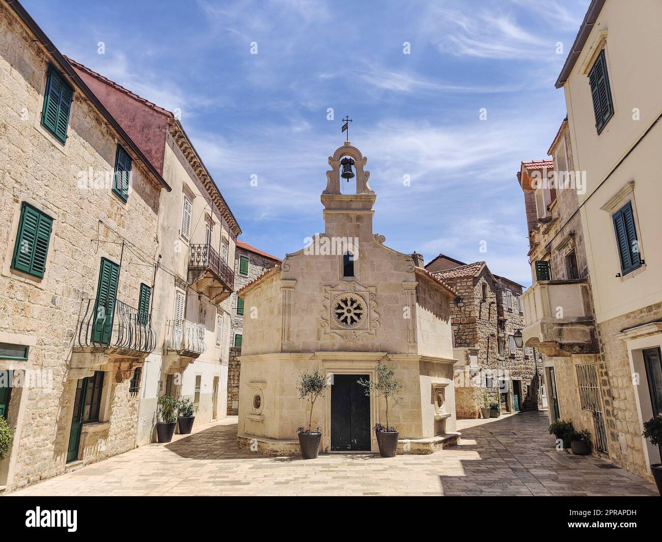 Piccola chiesa sulla piazza del piccolo villaggio urbano di Stari grad sull'isola di Hvar in Croazia, mare Adriatico, Europa. Foto Stock