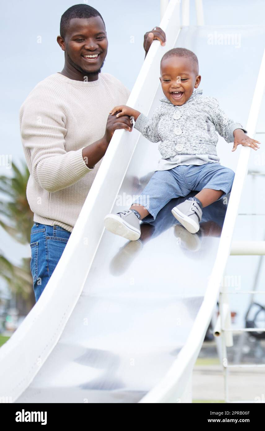 Fate quello che conta, ora: Un padre e un figlio che giocano nel parco. Foto Stock