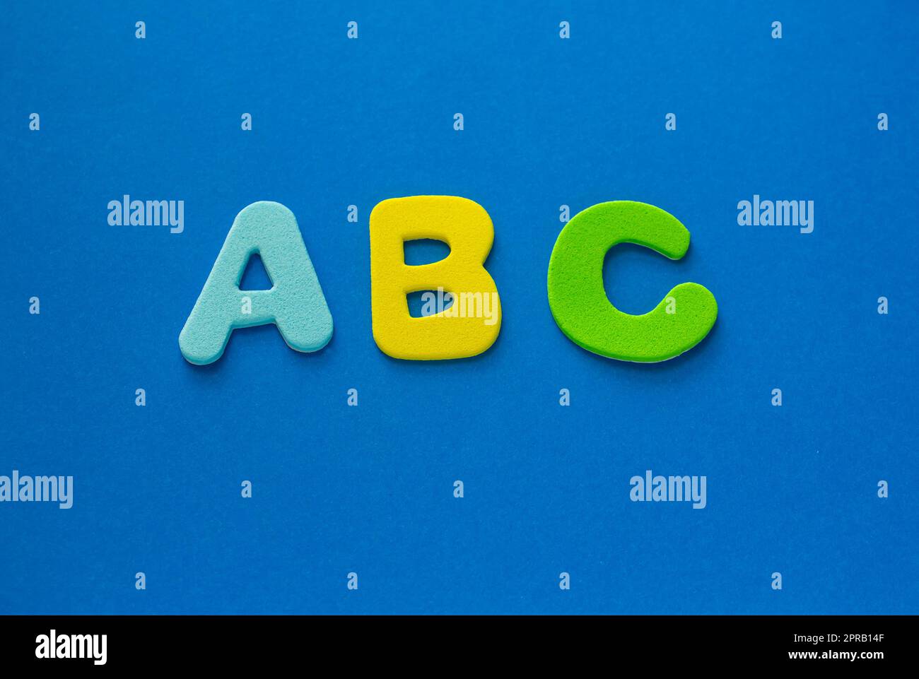 Gli inizi della scuola. ABC lettere colorate su sfondo blu, copia spazio. Inglese per principianti con spazio Copia. Foto Stock