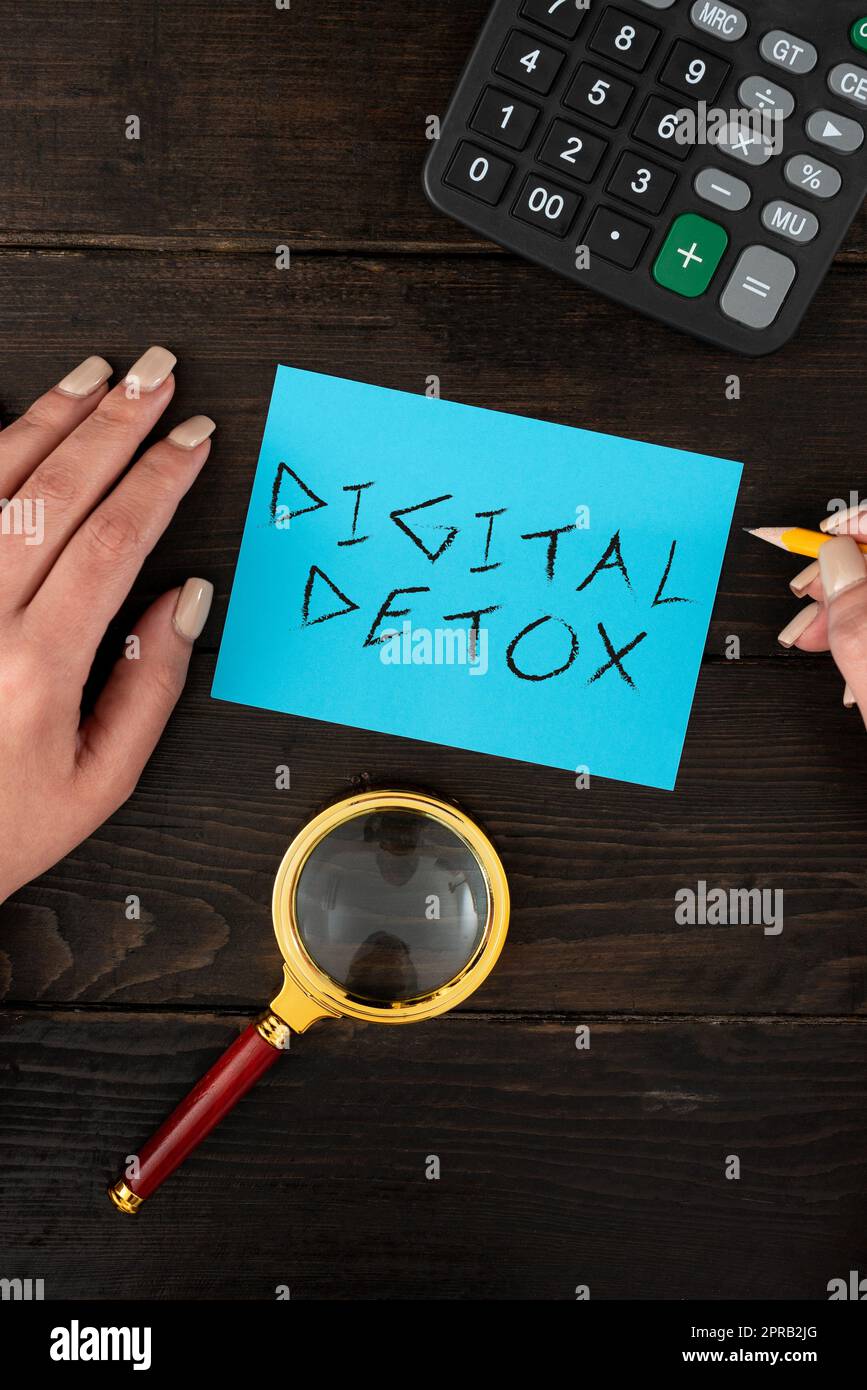 Cartello con deetox digitale. Foto concettuale senza dispositivi elettronici Disconnetti per ricollegare le mani di donna scollegate con carta bianca e cancelleria per la pubblicità. Foto Stock