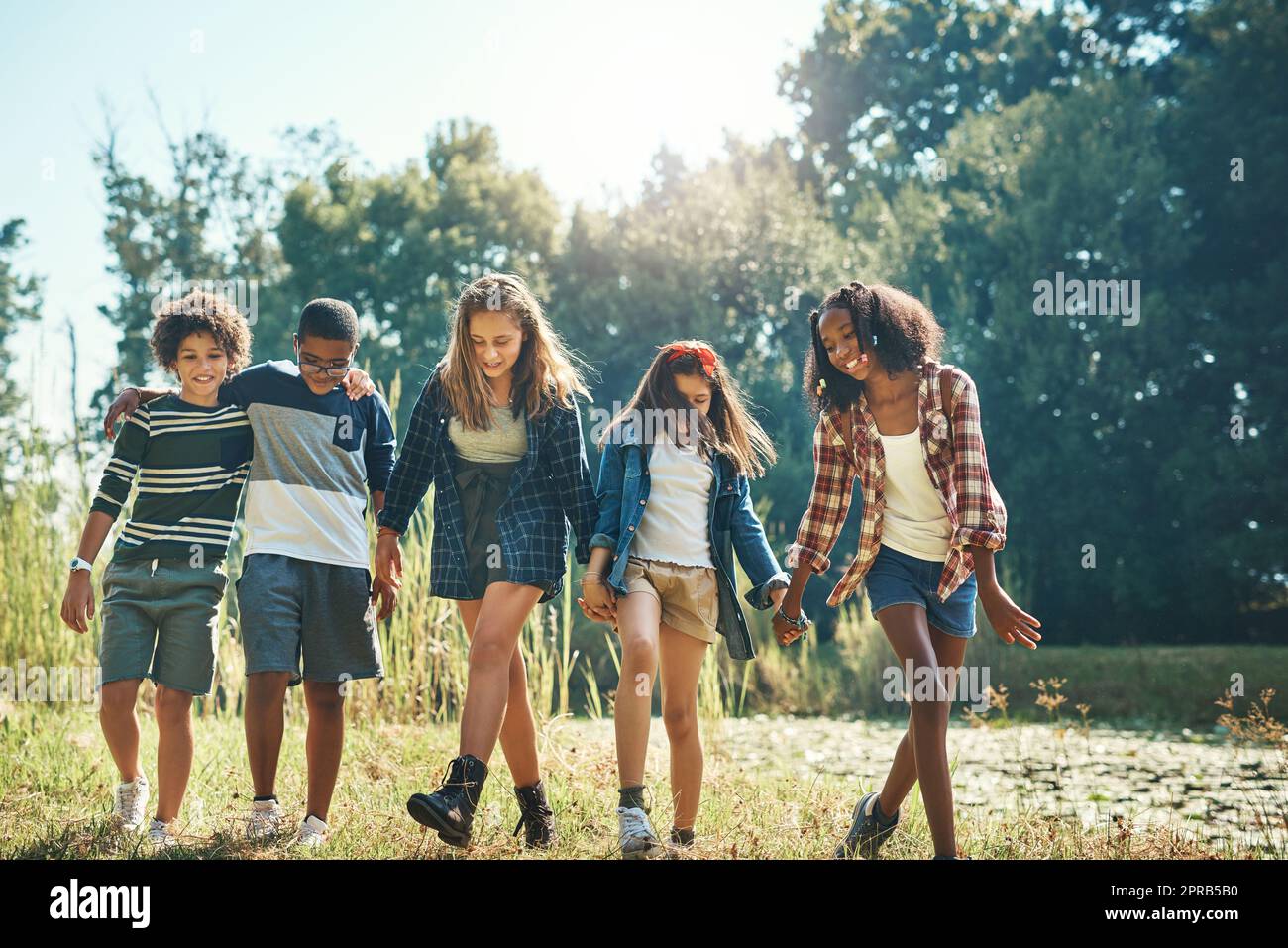 Un mondo di divertimento vi aspetta in natura. Un gruppo di adolescenti che camminano nella natura insieme al campo estivo. Foto Stock