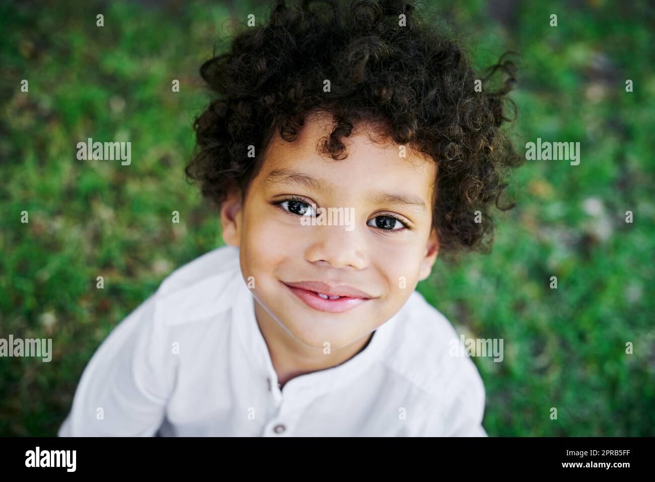 Sono troppo adorabile per la scuola, un ragazzino sorridente in natura. Foto Stock