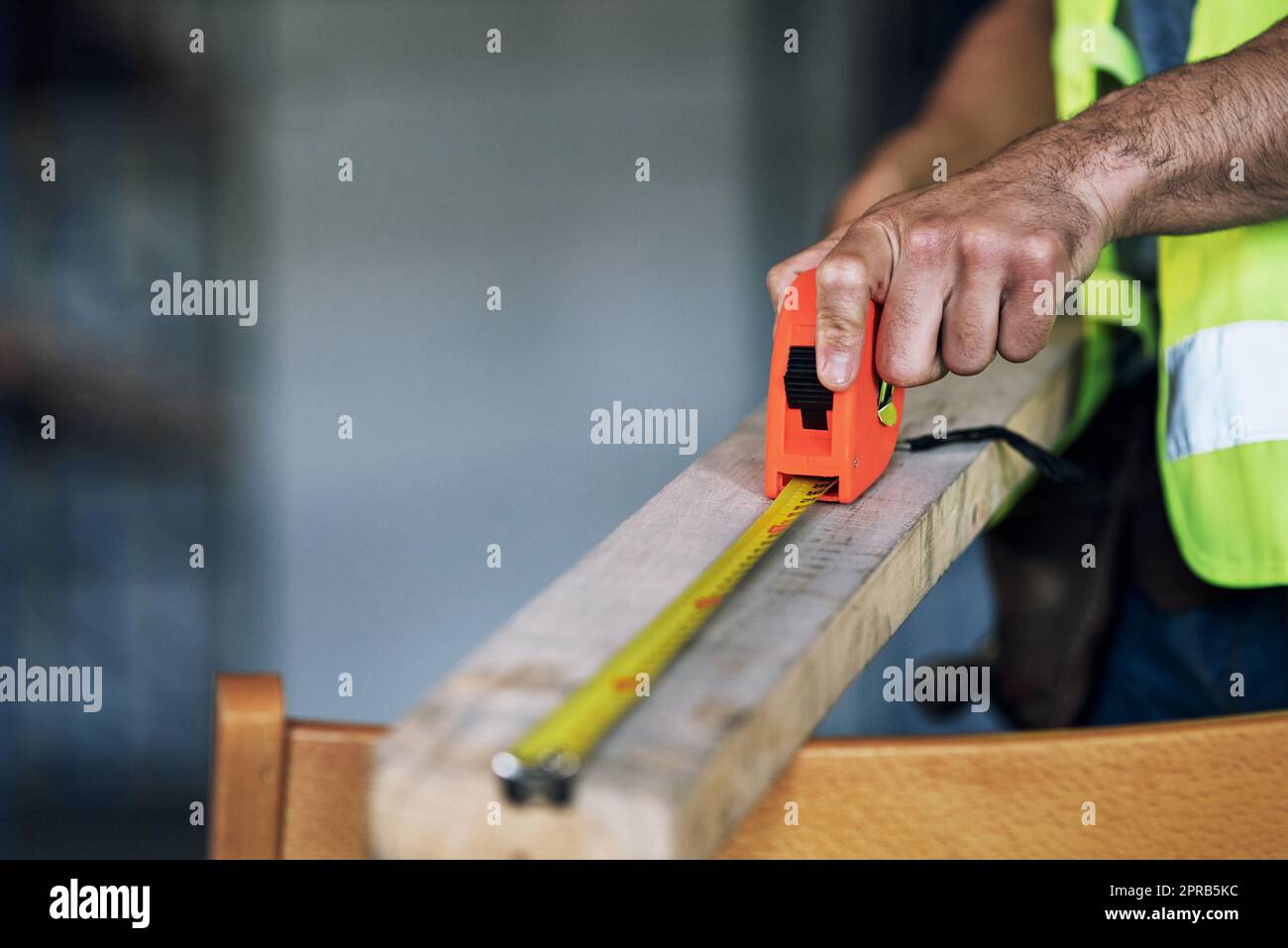 Il resto non misura fino a lui. Un costruttore che usa un nastro di misurazione in un cantiere. Foto Stock