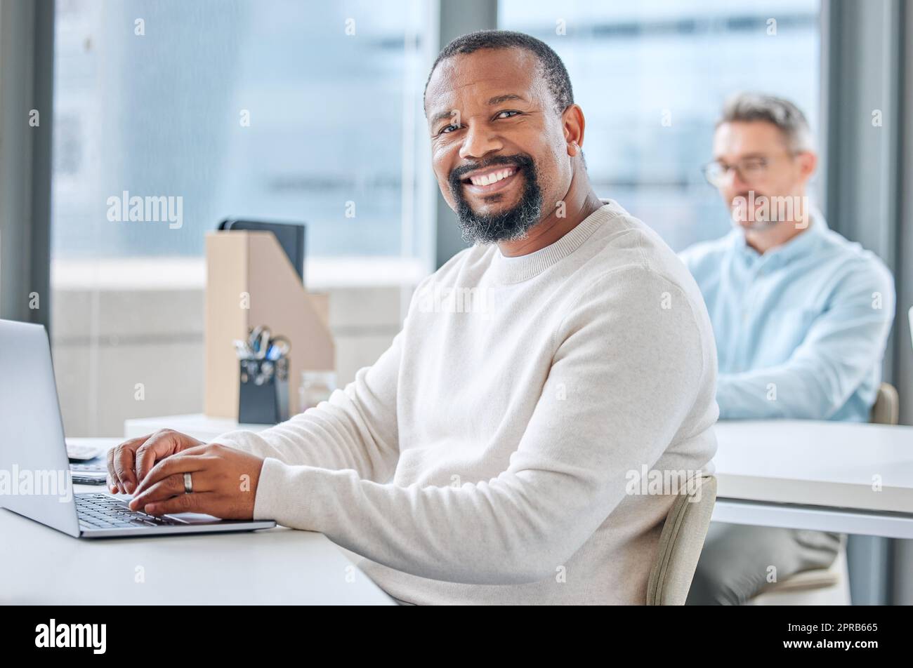 Im lavorando su qualcosa di grande qui. Ritratto di un uomo d'affari maturo che lavora su un laptop in un ufficio. Foto Stock