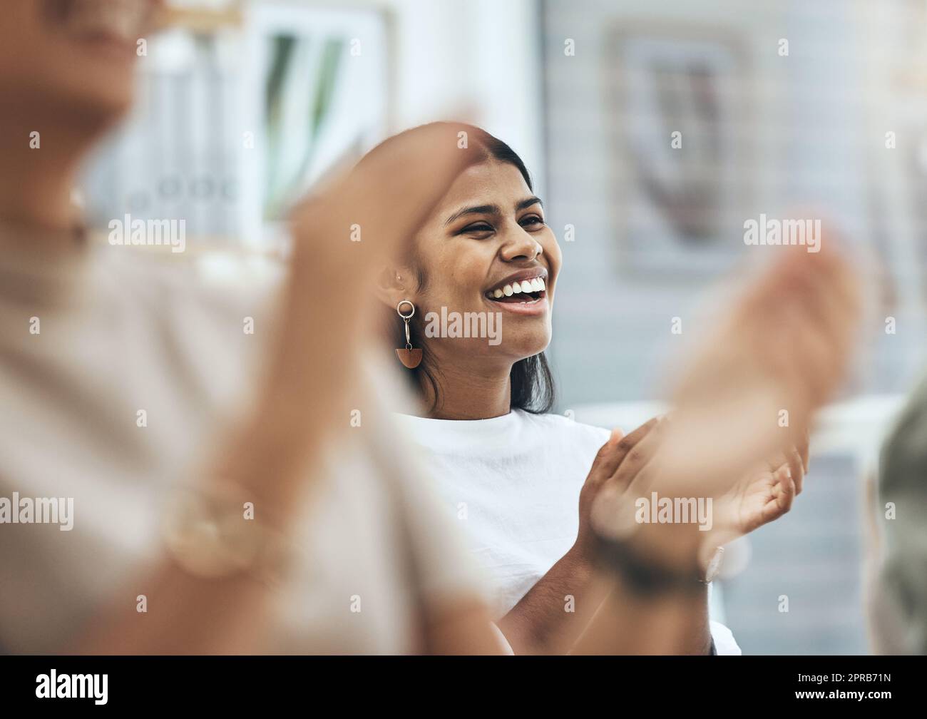 Ho potuto ascoltarlo tutto il giorno: Un gruppo di persone che batte e sorride durante una riunione di lavoro. Foto Stock