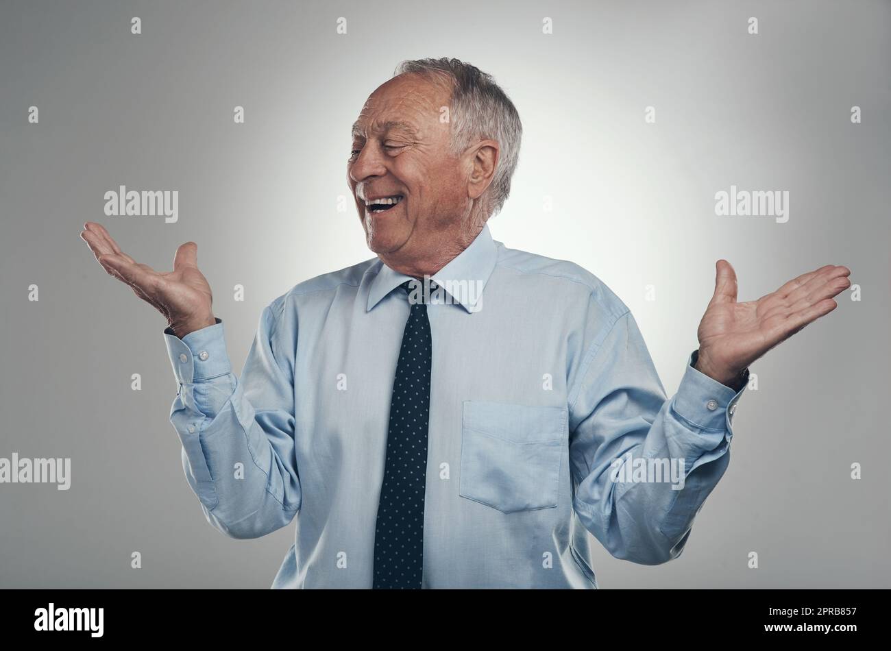 La pensione sta andando piuttosto bene in questo momento. un uomo d'affari anziano in piedi su uno sfondo grigio nello studio e che fa una scelta tra due opzioni. Foto Stock