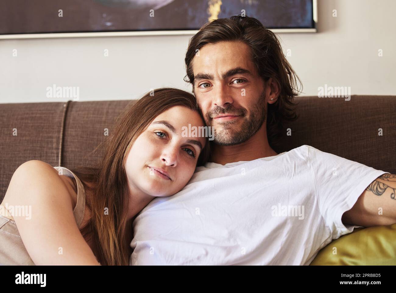 Una giovane coppia si rilassava sul divano di casa. Foto Stock