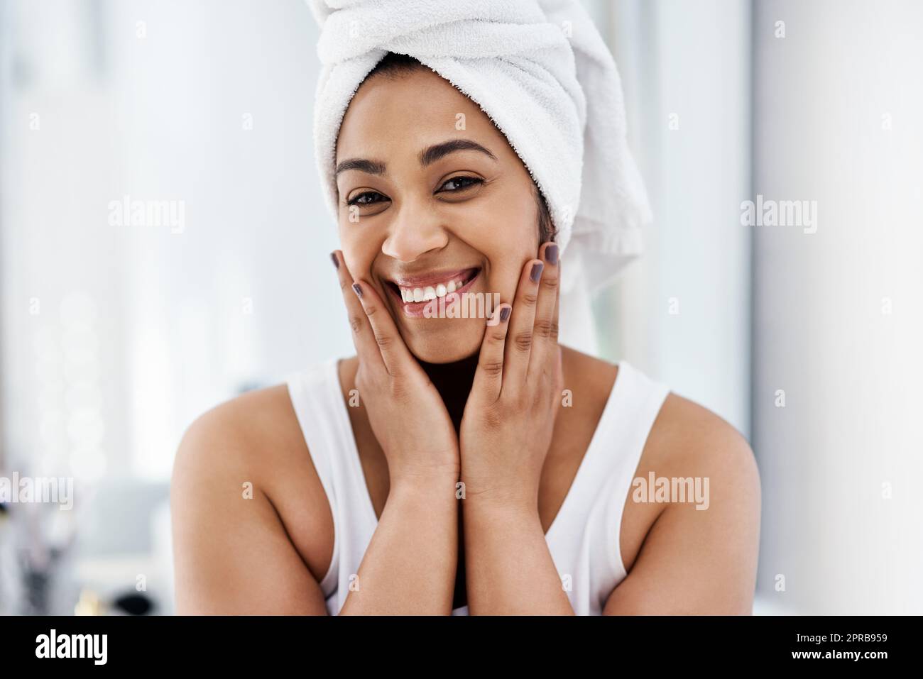Un sorriso per illuminare la vostra giornata. Una giovane donna che passa attraverso la sua routine di bellezza a casa. Foto Stock